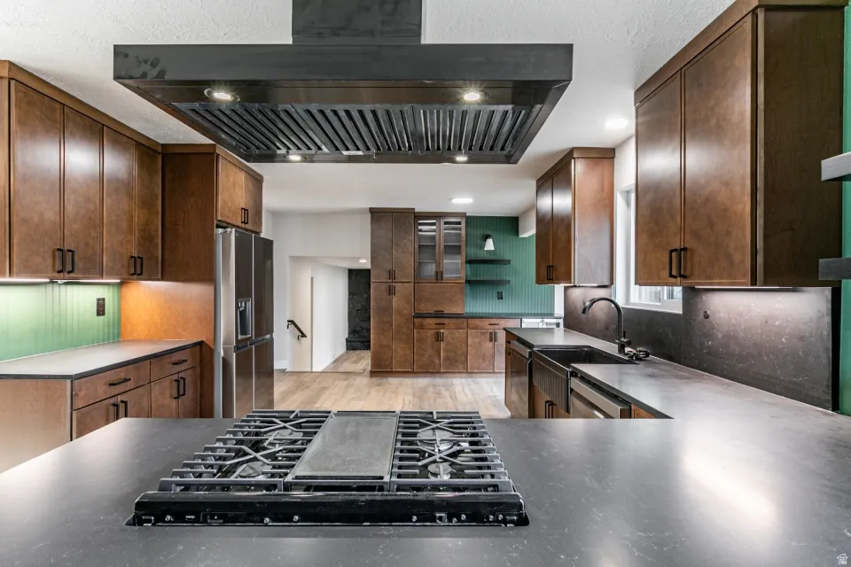 Kitchen with granite countertops, extractor fan, recessed lighting, stainless steel dishwasher, and a peninsula