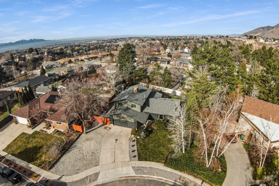 Aerial overview of property's location with nearby suburban area and a mountainous background