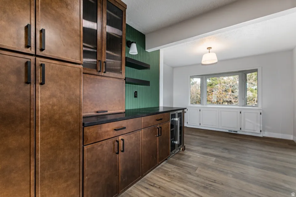 Kitchen with granite countertops, extractor fan, recessed lighting, stainless steel dishwasher, and a dining nook.