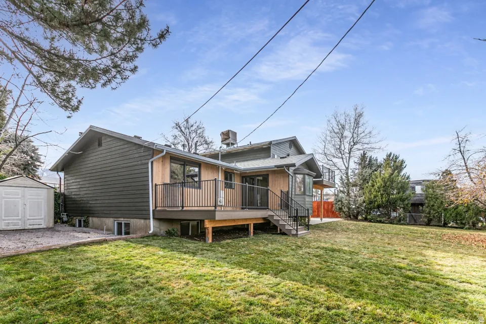 Back of house with a shed and a wooden deck