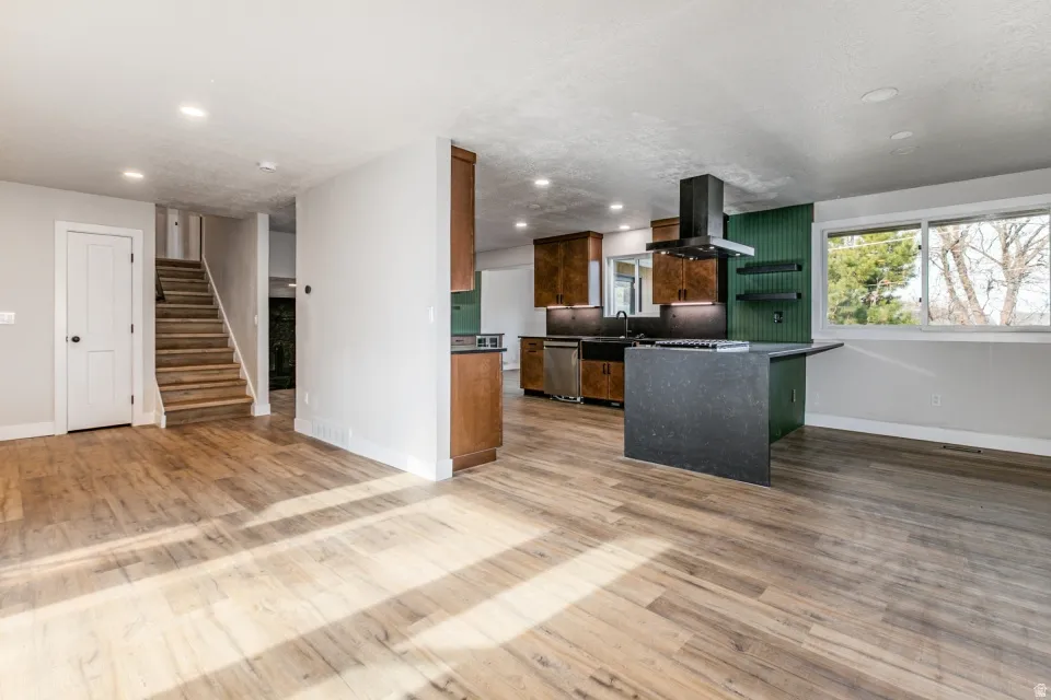 Kitchen with granite countertops, extractor fan, recessed lighting, stainless steel dishwasher, and a peninsula