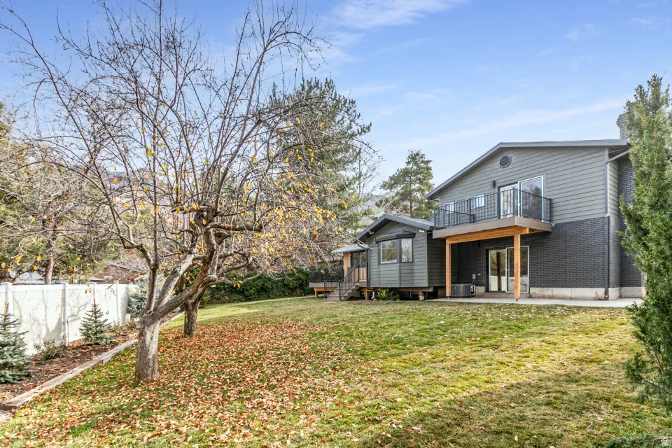 Back of property with a patio, brick siding, and a wooden deck