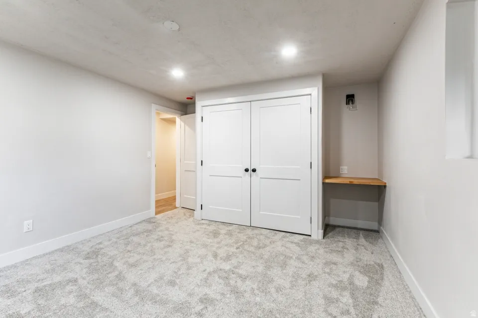 Unfurnished bedroom with light colored carpet, a closet, and recessed lighting