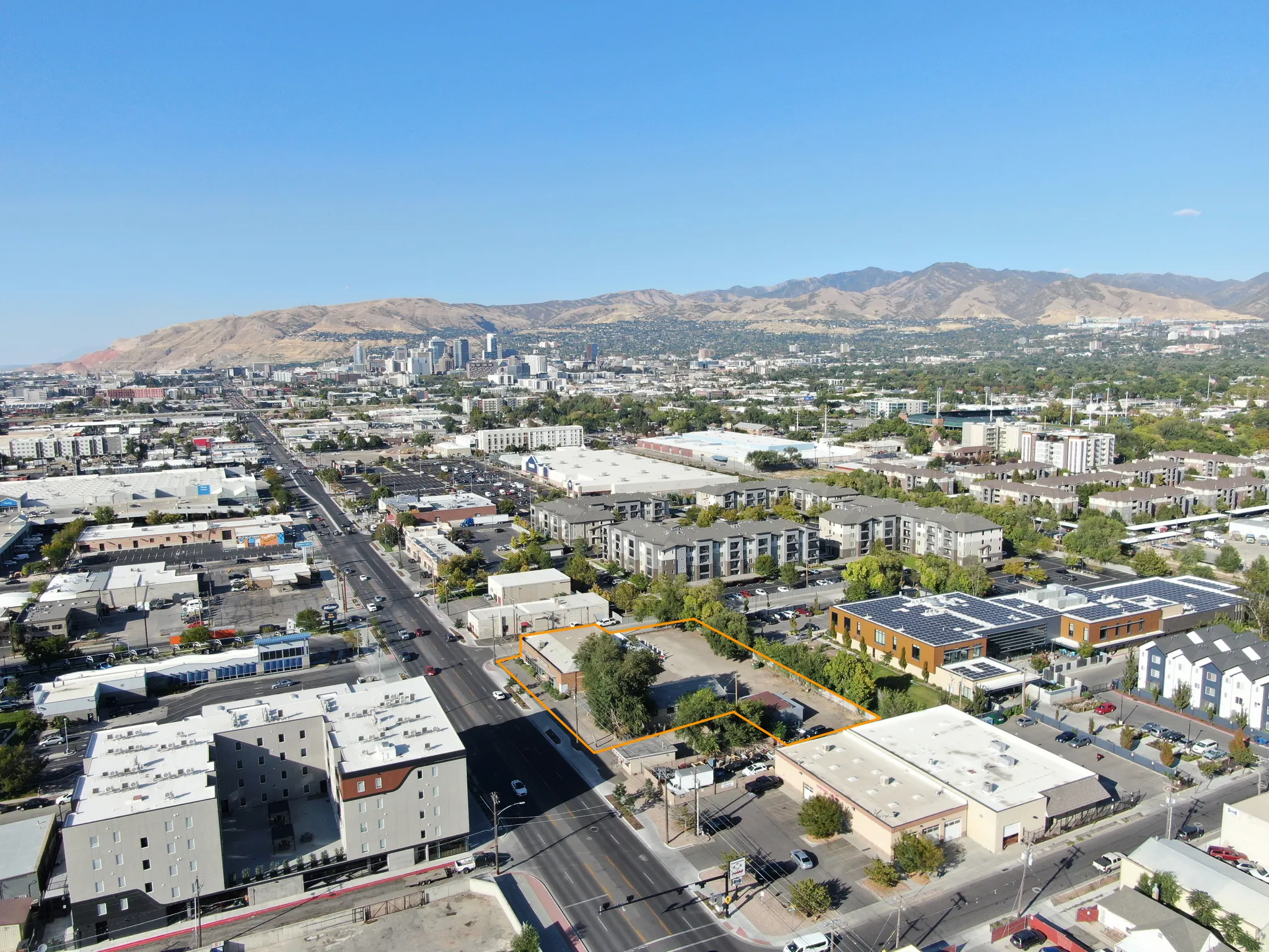 View of urban area with property parcel outlined and mountains