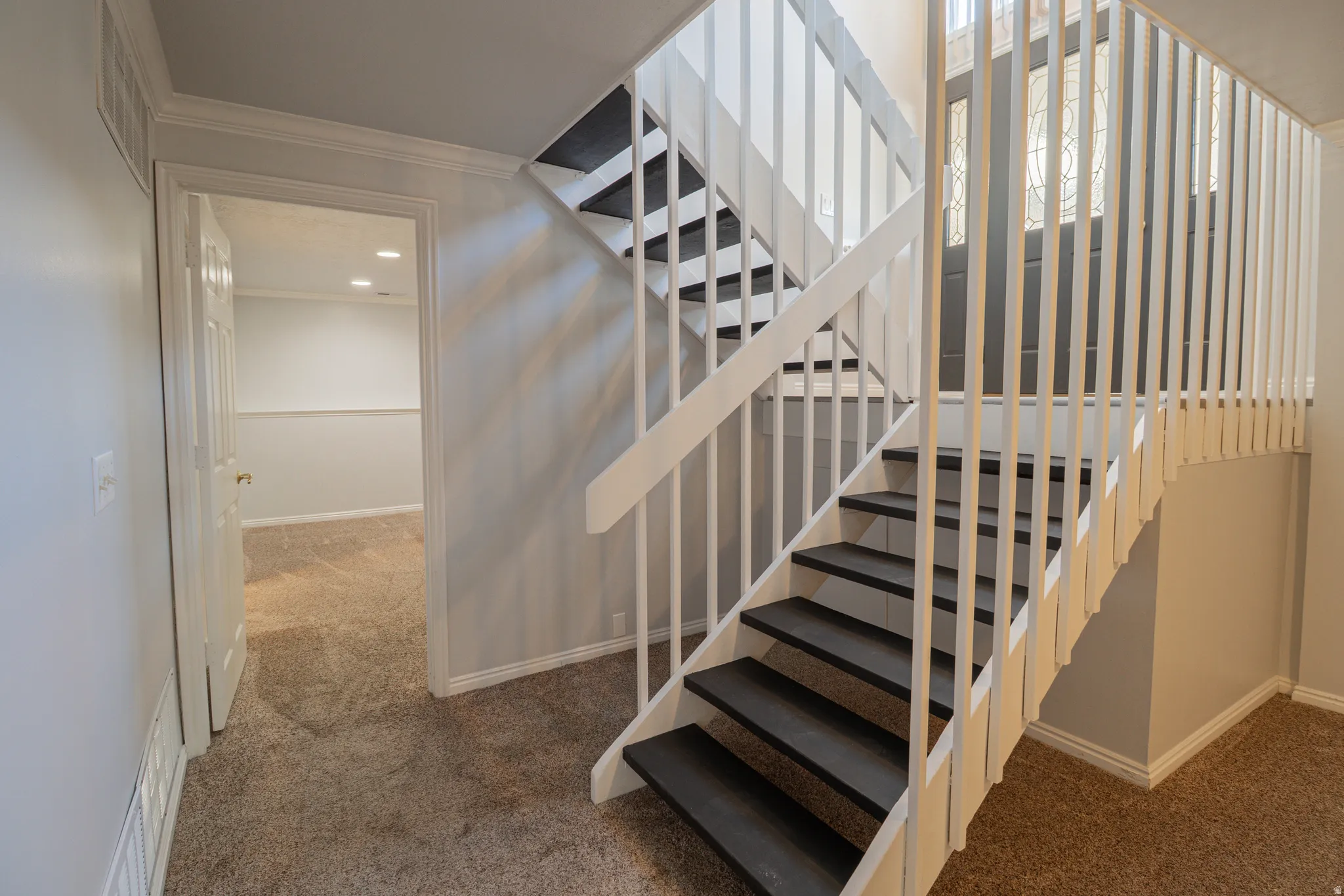 Staircase featuring ornamental molding and carpet