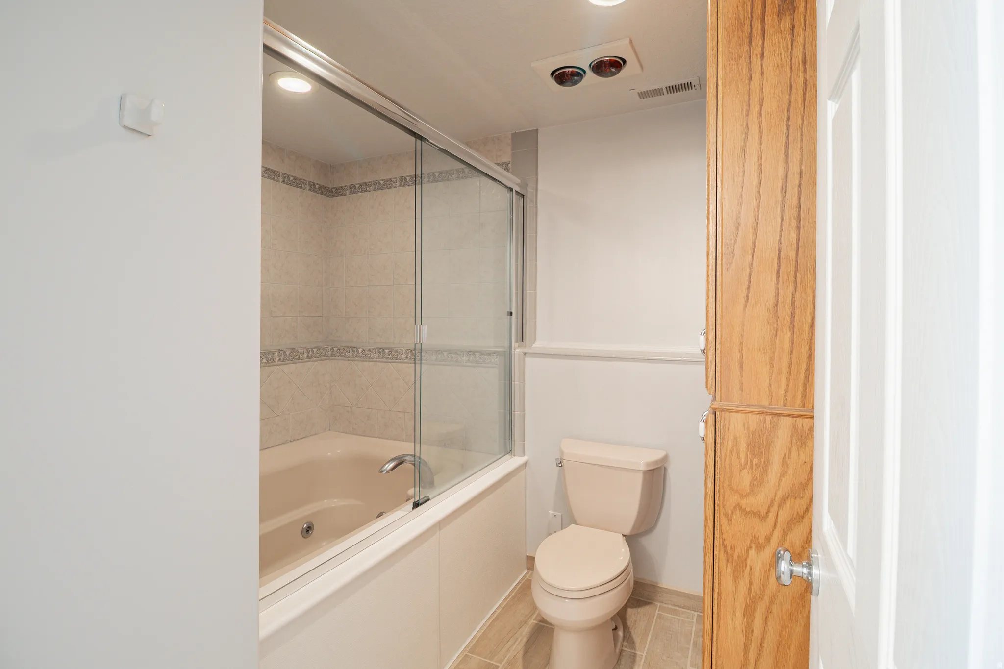 Full bathroom with combined bath / shower with glass door and recessed lighting