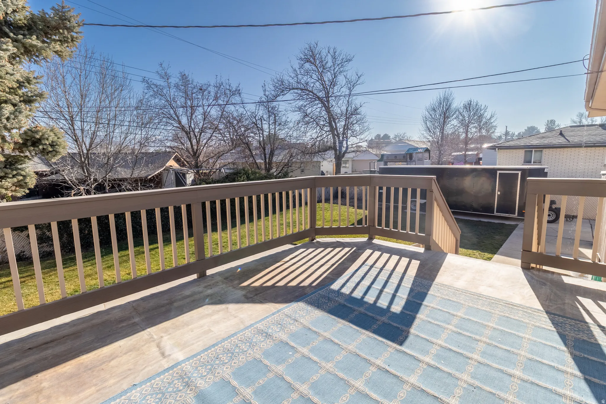Wooden deck with a residential view and a lawn