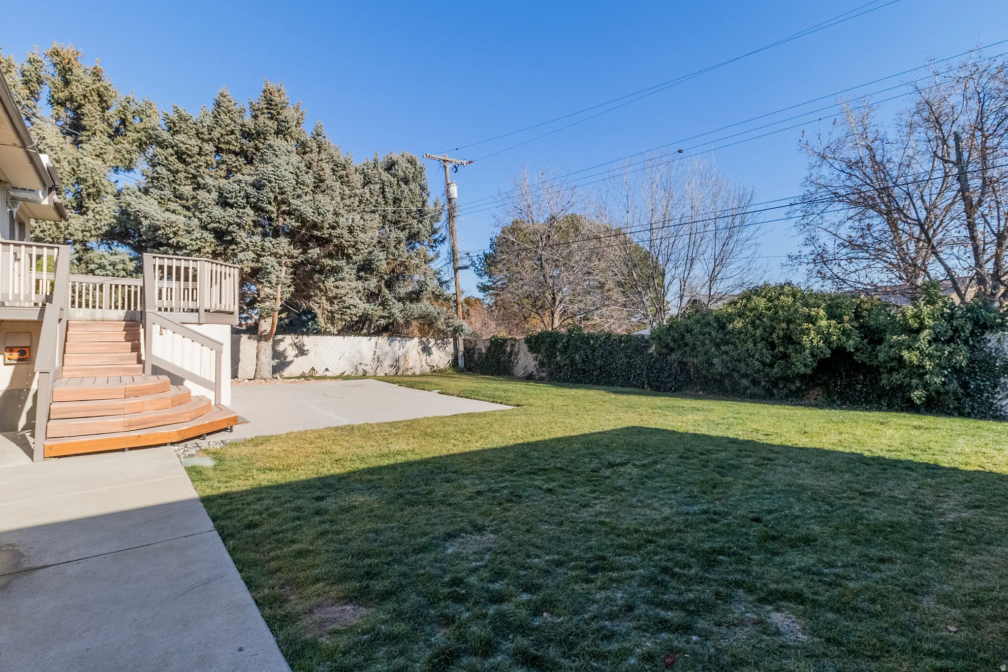 Fenced backyard featuring a deck, a patio, and stairs
