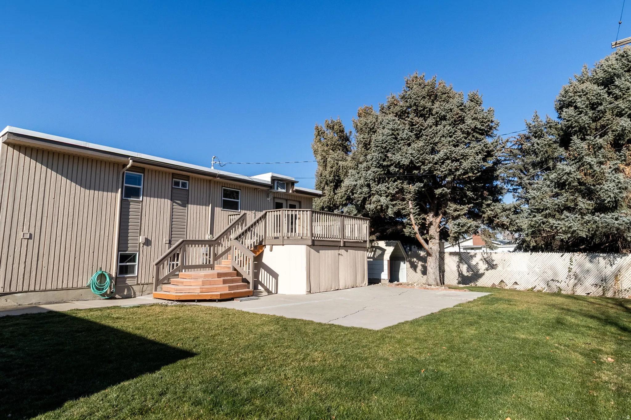 Rear view of house with a patio area, stairs, and a deck
