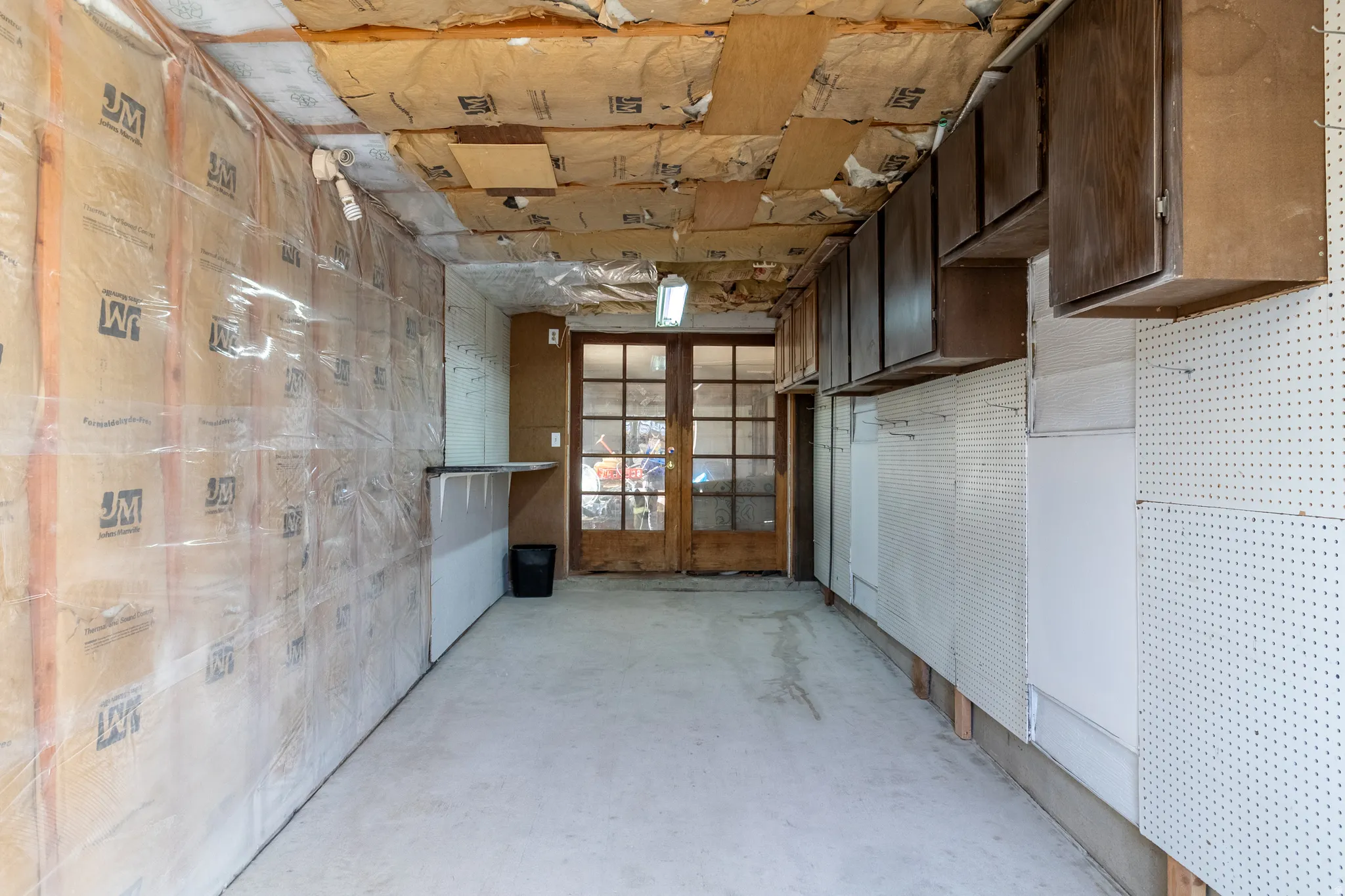Misc room featuring unfinished concrete floors and french doors