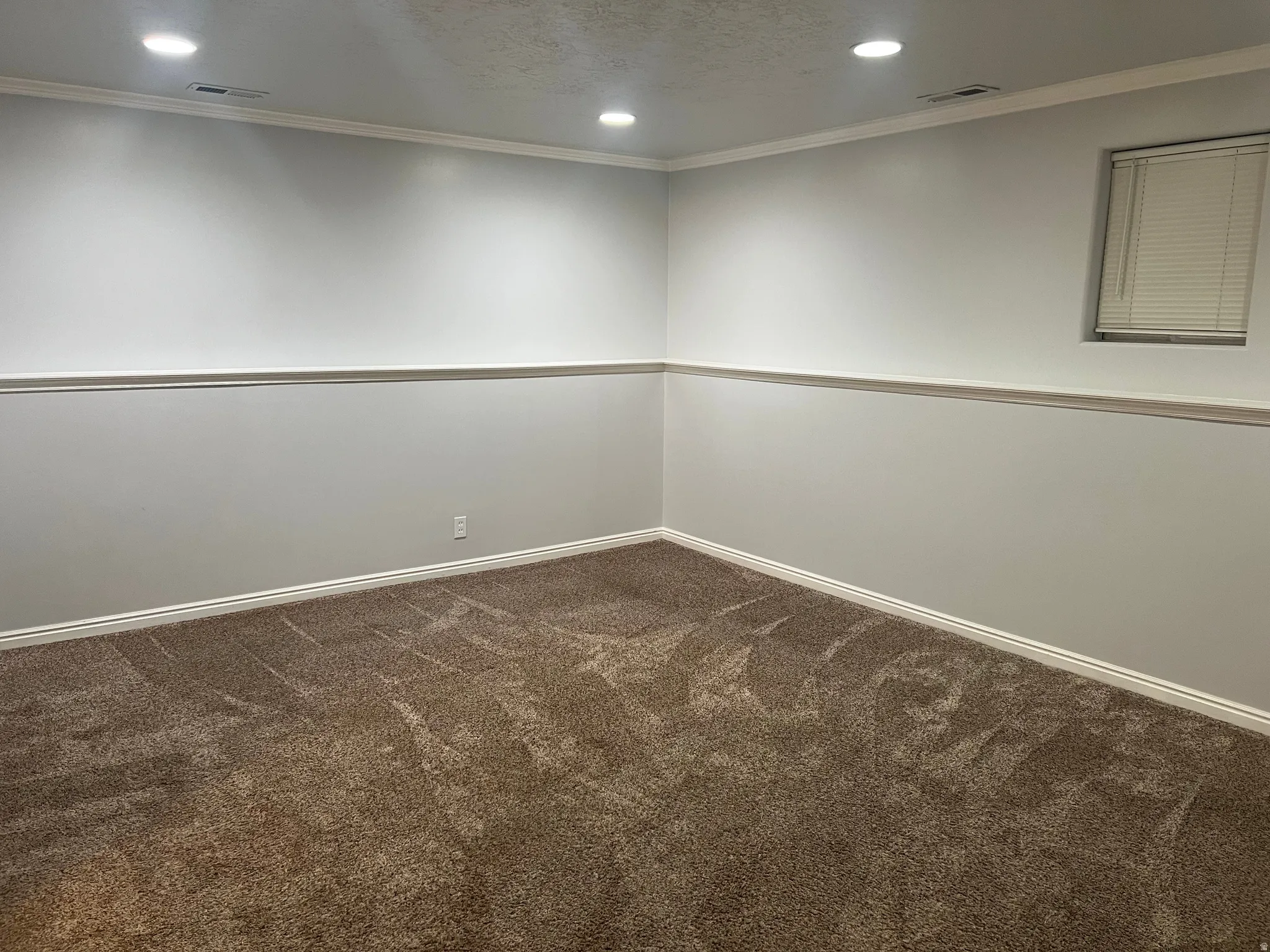 Spare room with recessed lighting, dark carpet, ornamental molding, and a textured ceiling