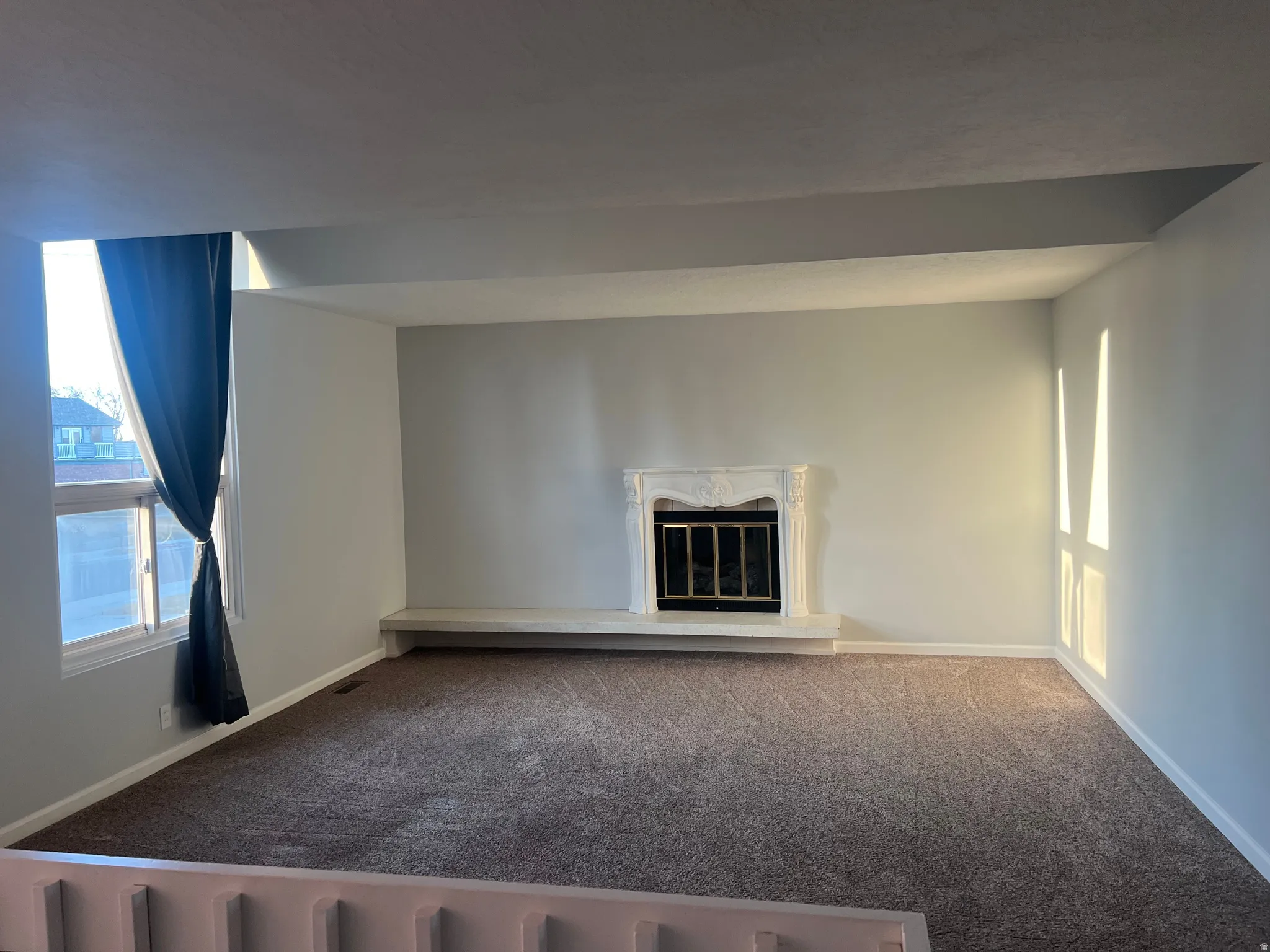 Unfurnished living room with carpet and a premium fireplace