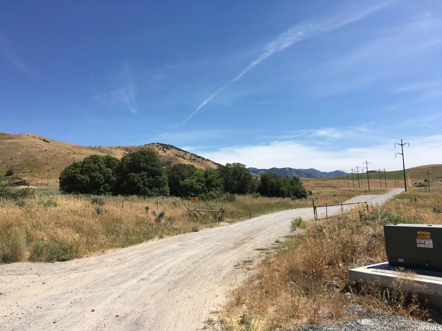 View of dirt / gravel road with a view of rural / pastoral area and a mountain view