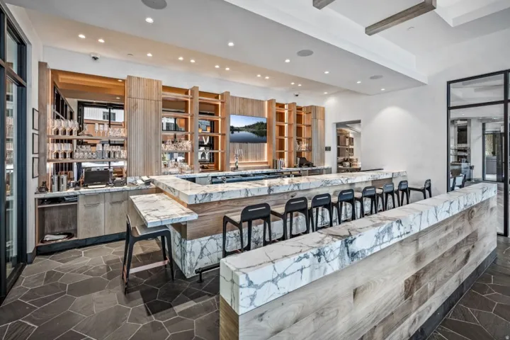Kitchen featuring a kitchen breakfast bar, recessed lighting, light stone counters, a peninsula, and modern cabinets