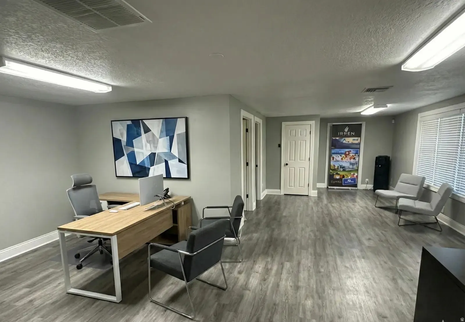 Office area with a textured ceiling and wood finished floors