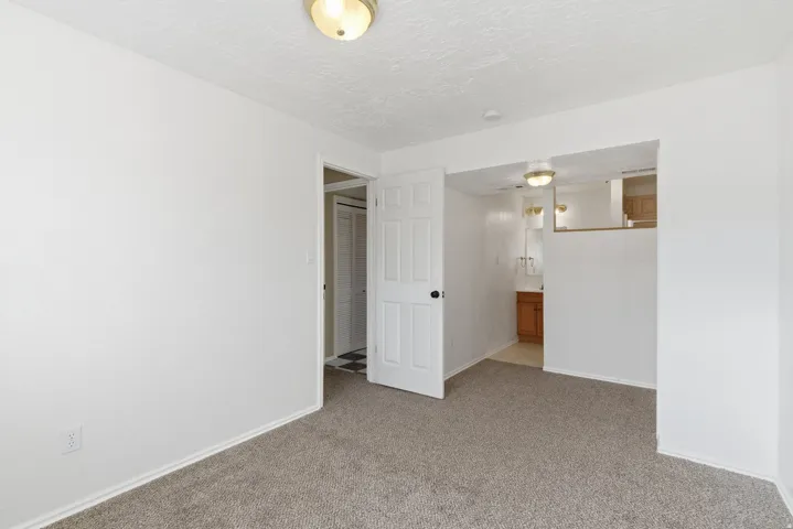 Spare room featuring a textured ceiling and light carpet