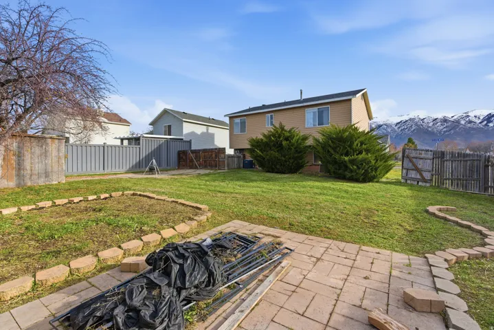 Fenced backyard with a patio area, a gate, and a mountain view