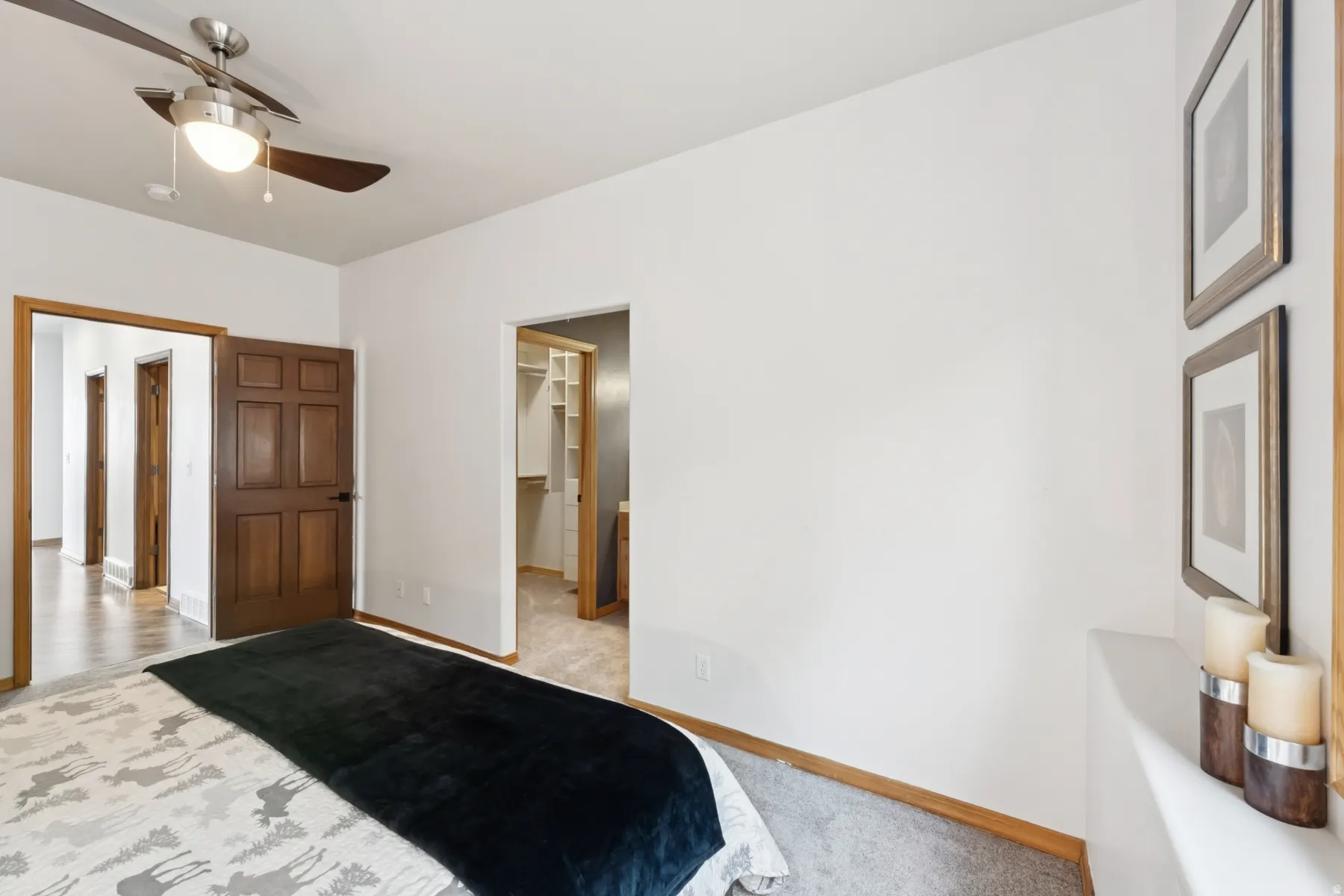 Bedroom featuring a ceiling fan, light colored carpet, and a spacious closet
