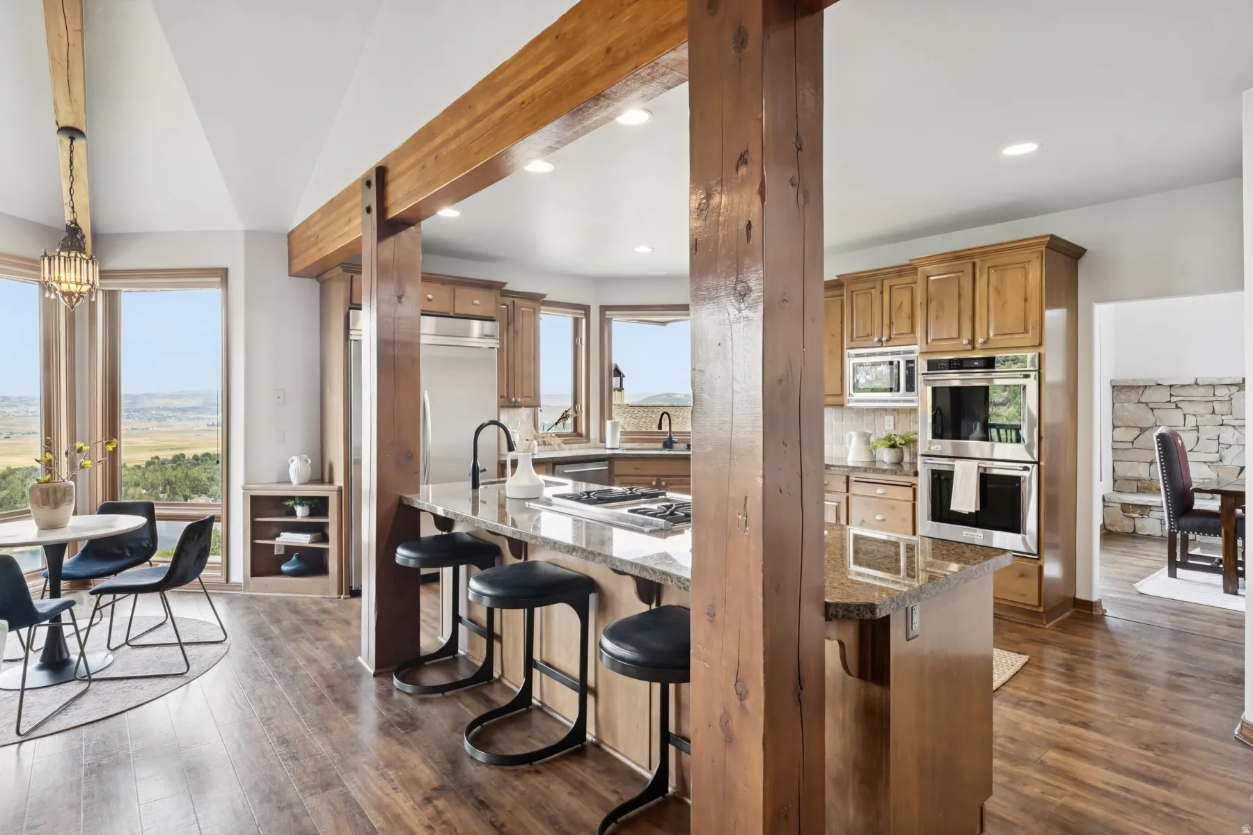 Kitchen with stainless steel appliances, healthy amount of natural light, brown cabinetry, dark wood finished floors, and recessed lighting