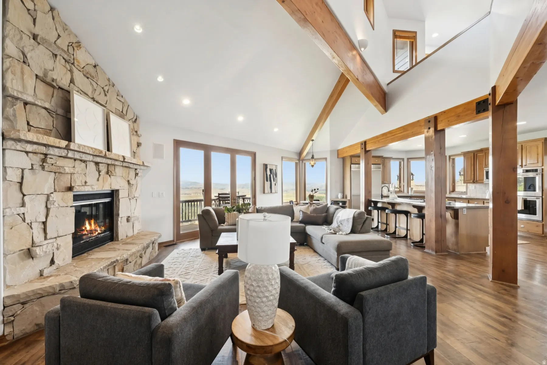 Living area featuring recessed lighting, dark wood-style floors, high vaulted ceiling, a fireplace, and beamed ceiling