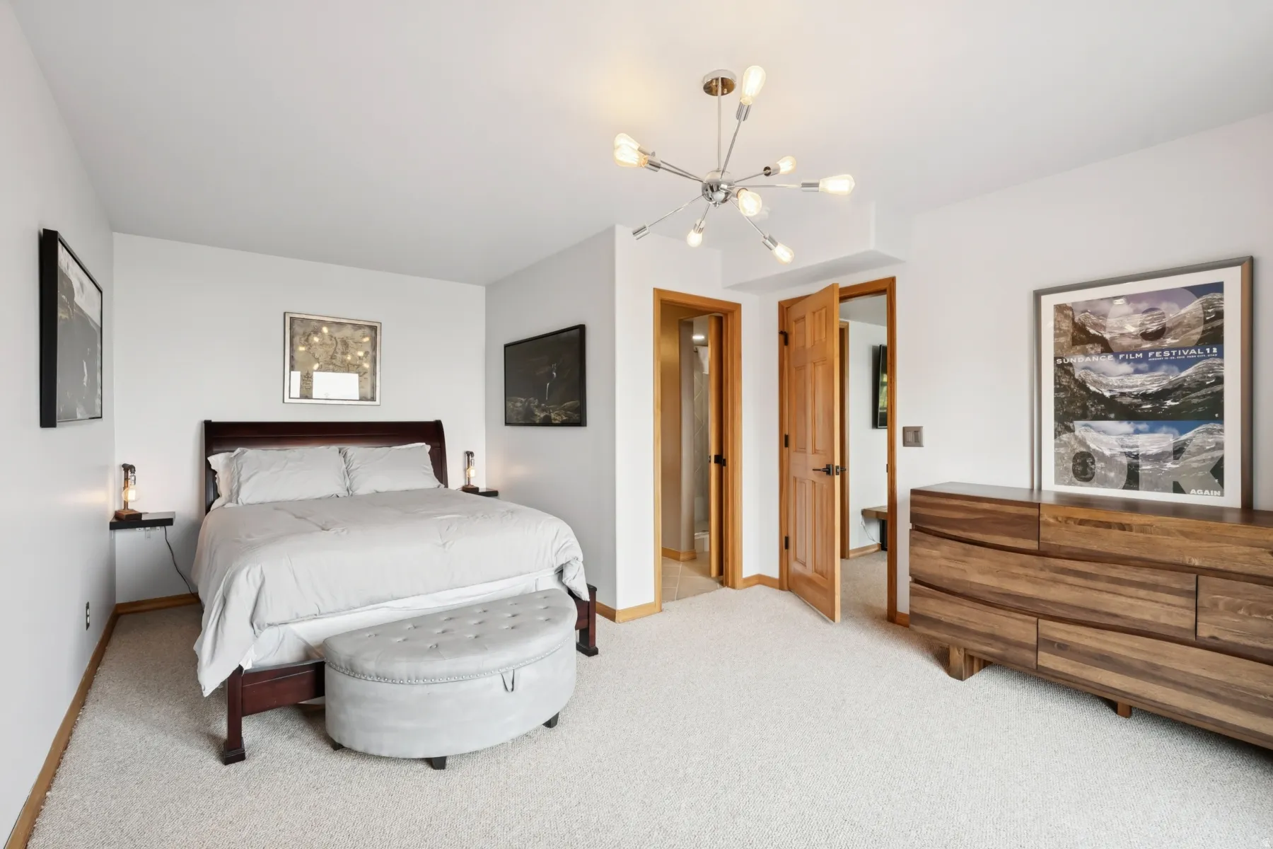 Carpeted bedroom featuring a chandelier and baseboards