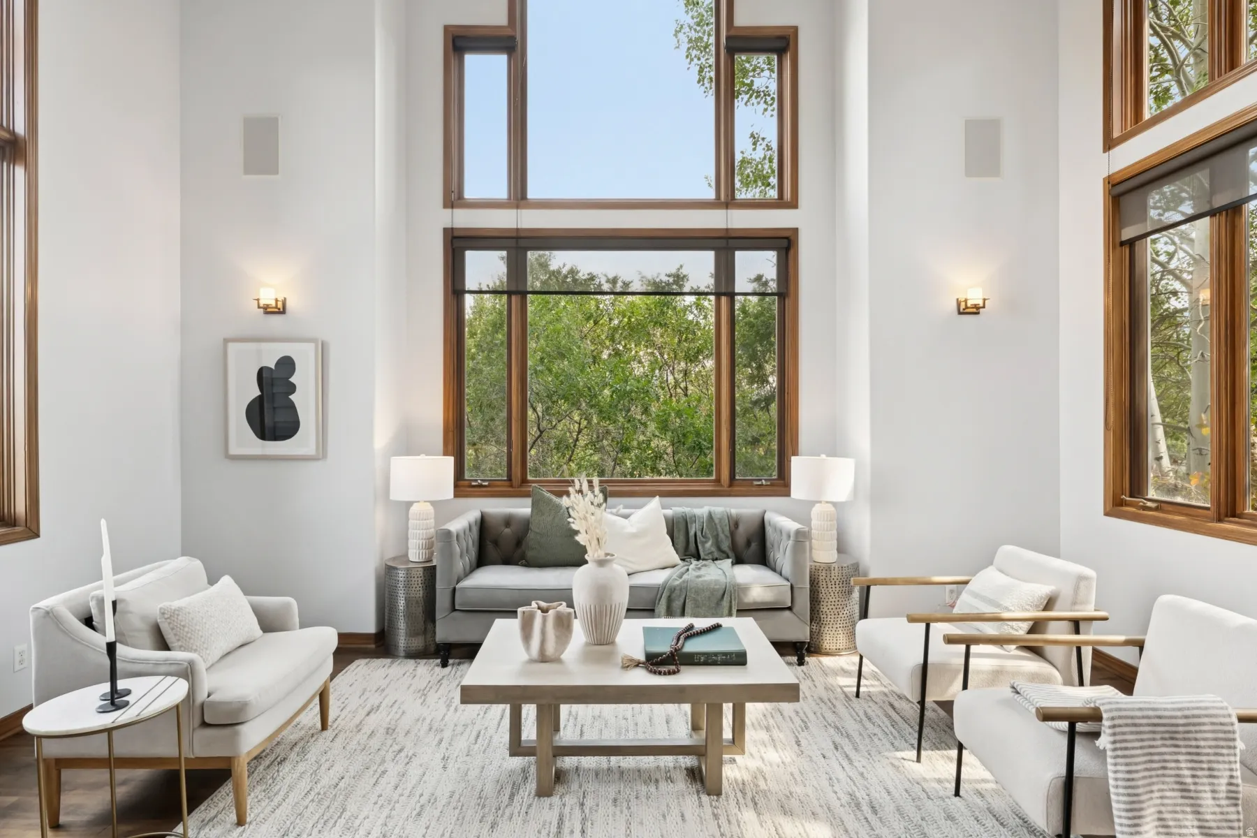 Living area featuring a high ceiling, wood finished floors, and plenty of natural light