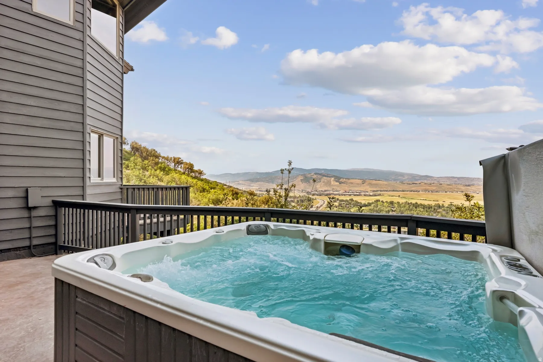 Balcony featuring a hot tub and a mountain view