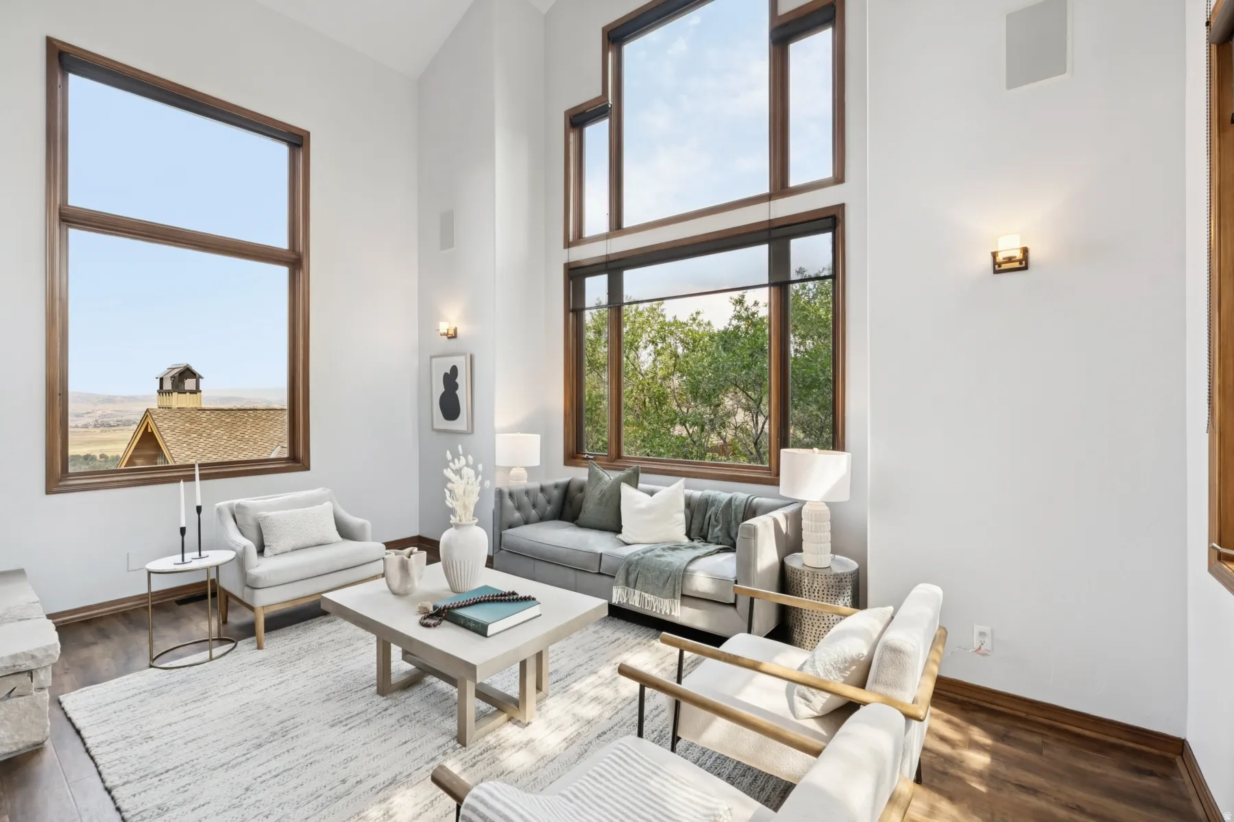Living room with a towering ceiling, wood finished floors, and plenty of natural light
