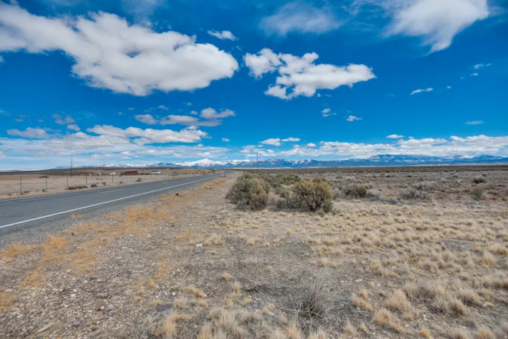 View of asphalt road featuring a view of rural / pastoral area and a mountain view