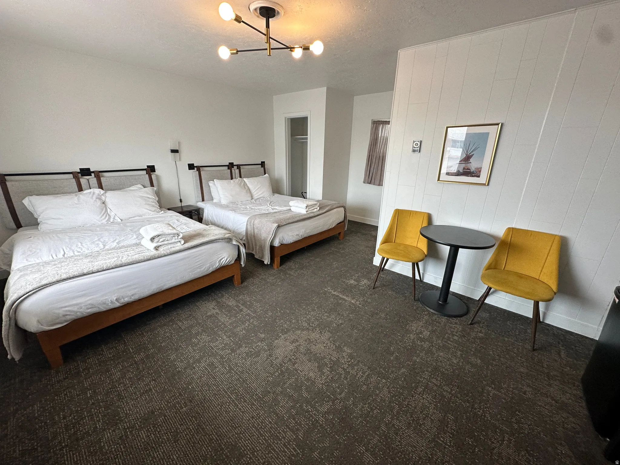 Bedroom featuring a textured ceiling, dark colored carpet, and a chandelier