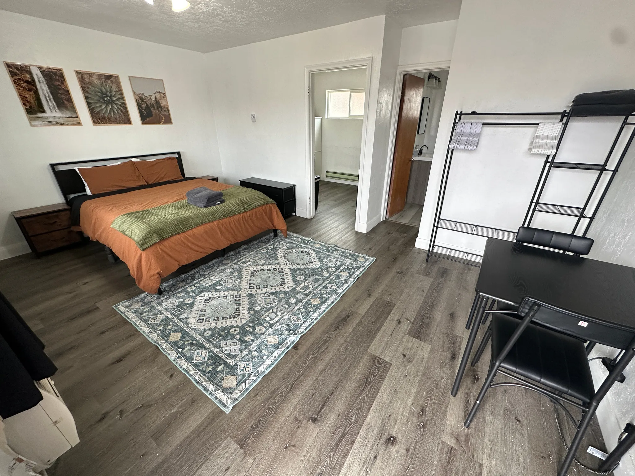 Bedroom with a textured ceiling, wood finished floors, and baseboard heating