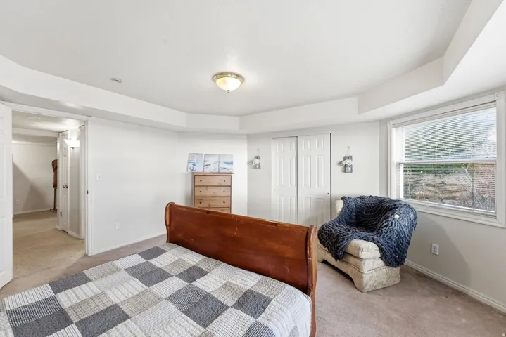 Carpeted bedroom with baseboards and a closet