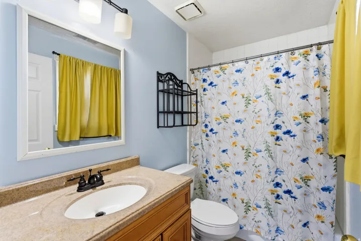 Full bathroom with vanity and a textured ceiling