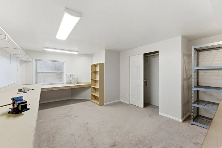 Unfurnished office featuring built in desk and light carpet