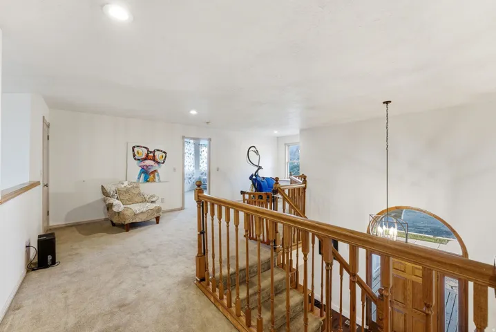 Corridor with recessed lighting, an upstairs landing, light colored carpet, and a chandelier