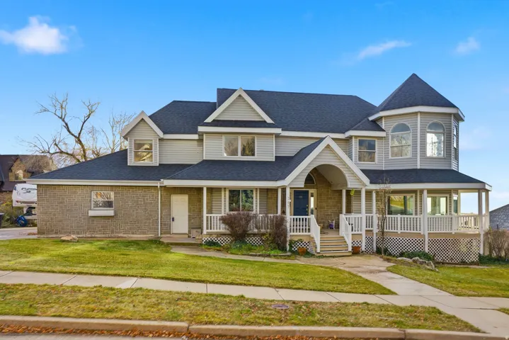 View of front of home featuring a porch, roof with shingles, and a front lawn