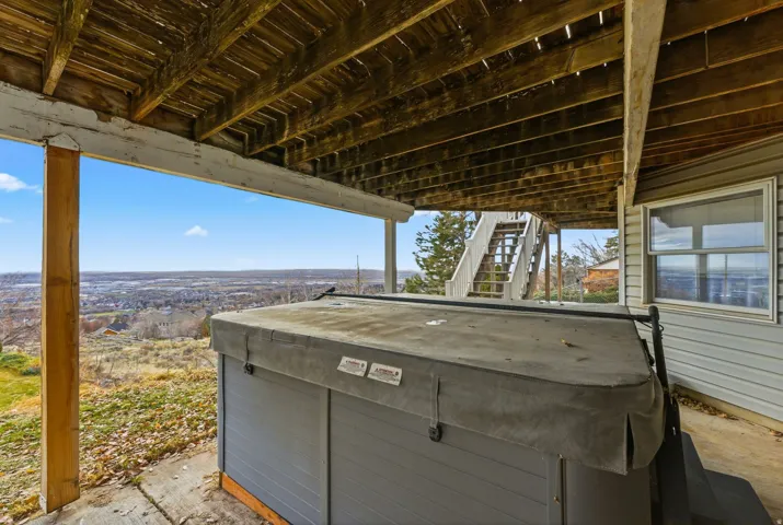 View of patio featuring stairway and a hot tub