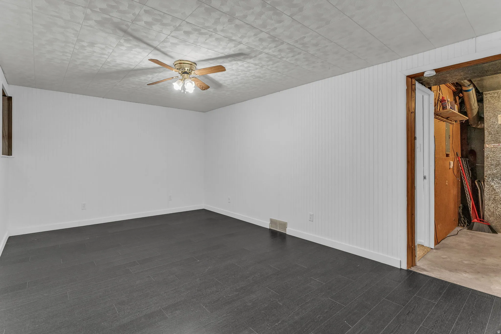 Unfurnished room with a ceiling fan and dark wood finished floors