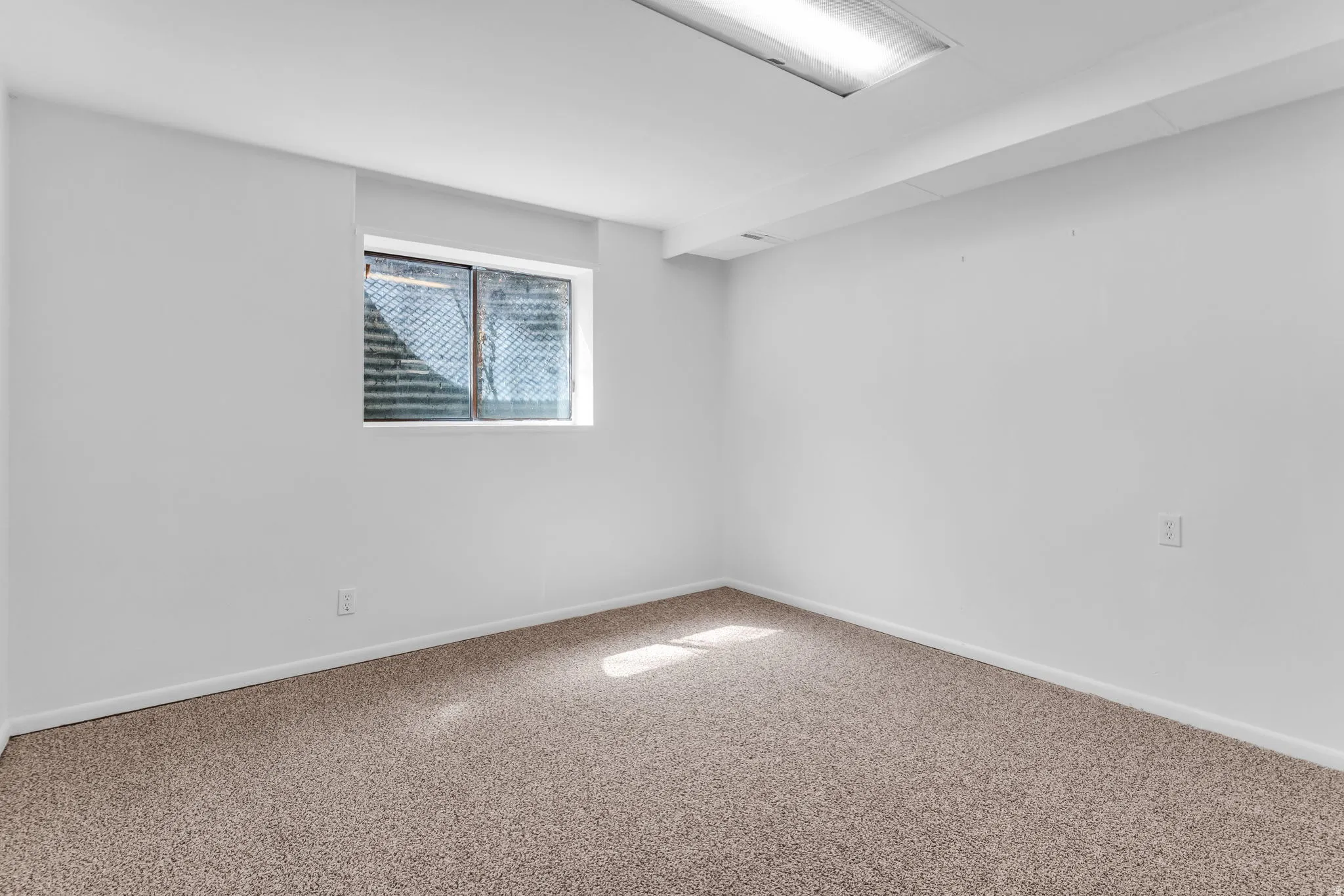 Carpeted spare room featuring baseboards