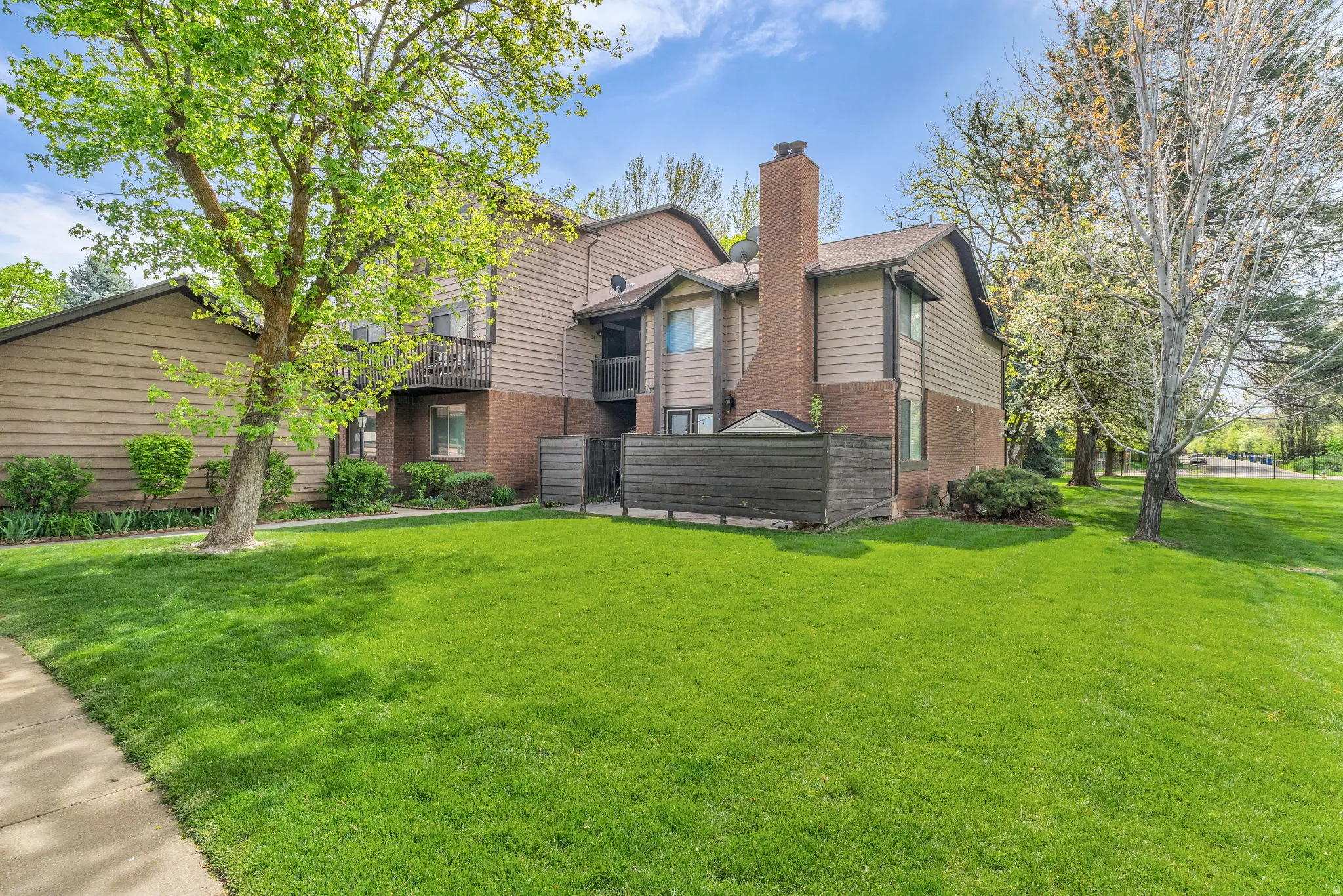 View of front facade featuring brick siding, a front lawn, and a chimney