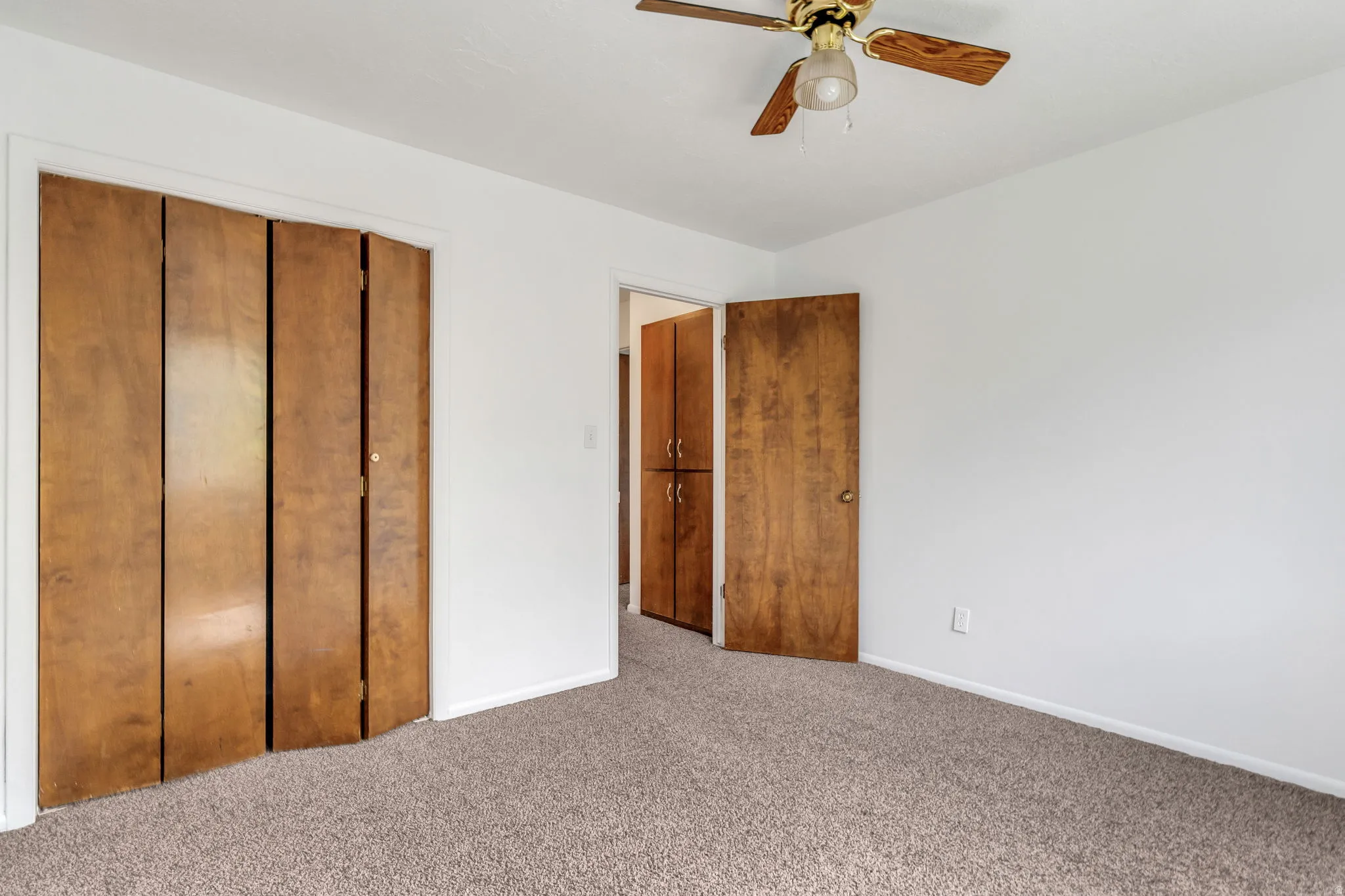 Unfurnished bedroom featuring a closet, ceiling fan, and carpet floors