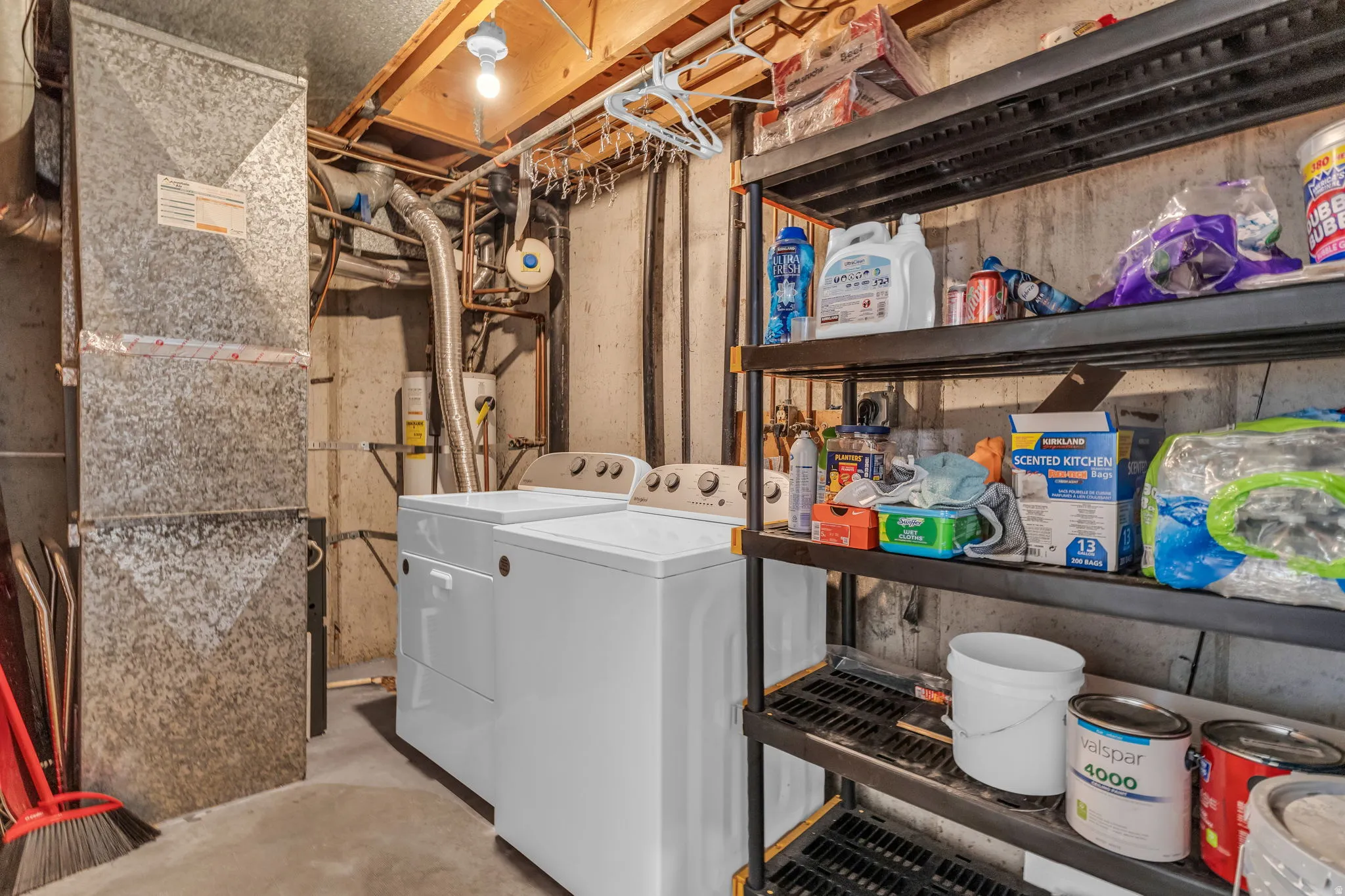 Laundry area featuring gas water heater, concrete flooring, washer and dryer, and heating unit