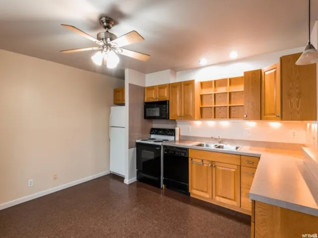 Kitchen featuring black appliances, open shelves, light countertops, pendant lighting, and a ceiling fan