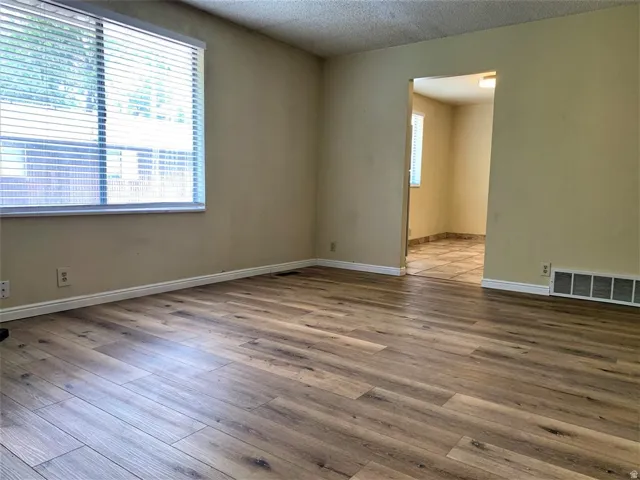 Spare room featuring wood finished floors and a textured ceiling