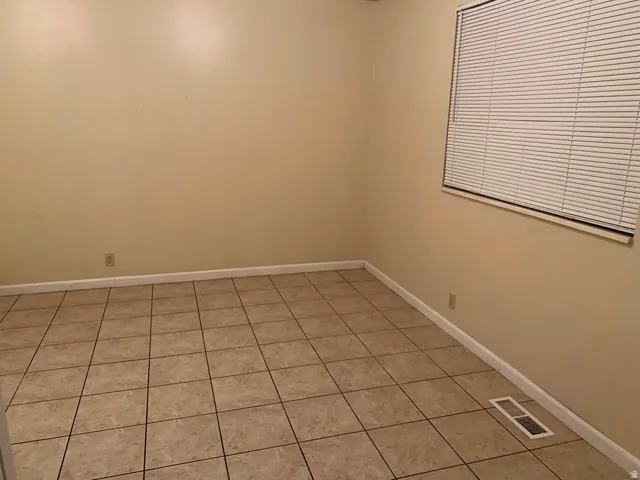 Spare room with light tile patterned flooring and baseboards