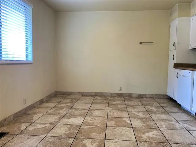 Unfurnished dining area with light tile patterned flooring and baseboards