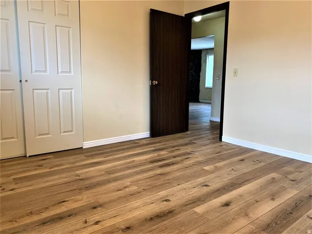 Unfurnished bedroom featuring wood finished floors and a closet