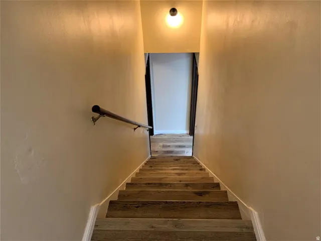 Stairs with wood-type flooring and baseboards