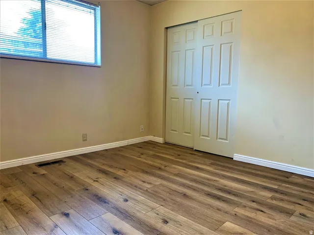 Unfurnished bedroom featuring dark wood-type flooring and a closet