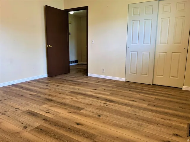 Unfurnished bedroom featuring wood-type flooring and a closet